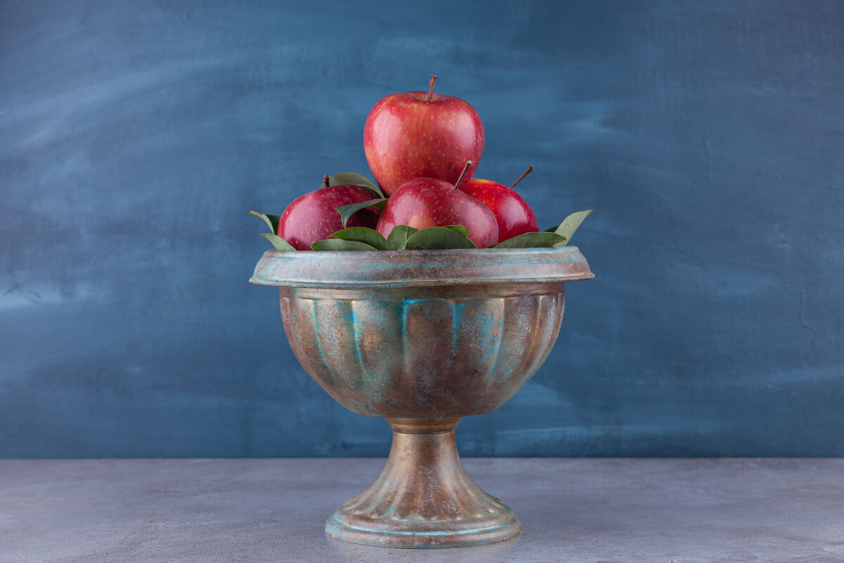 成熟在石头表面有闪亮的红苹果的深色碗有机水果美味