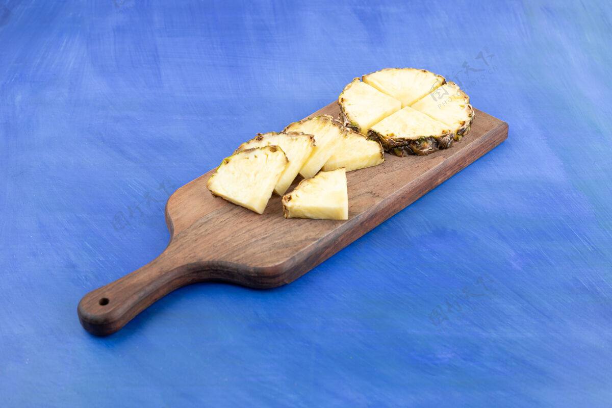 新鲜把菠萝切成蓝色的木板好吃食物成熟