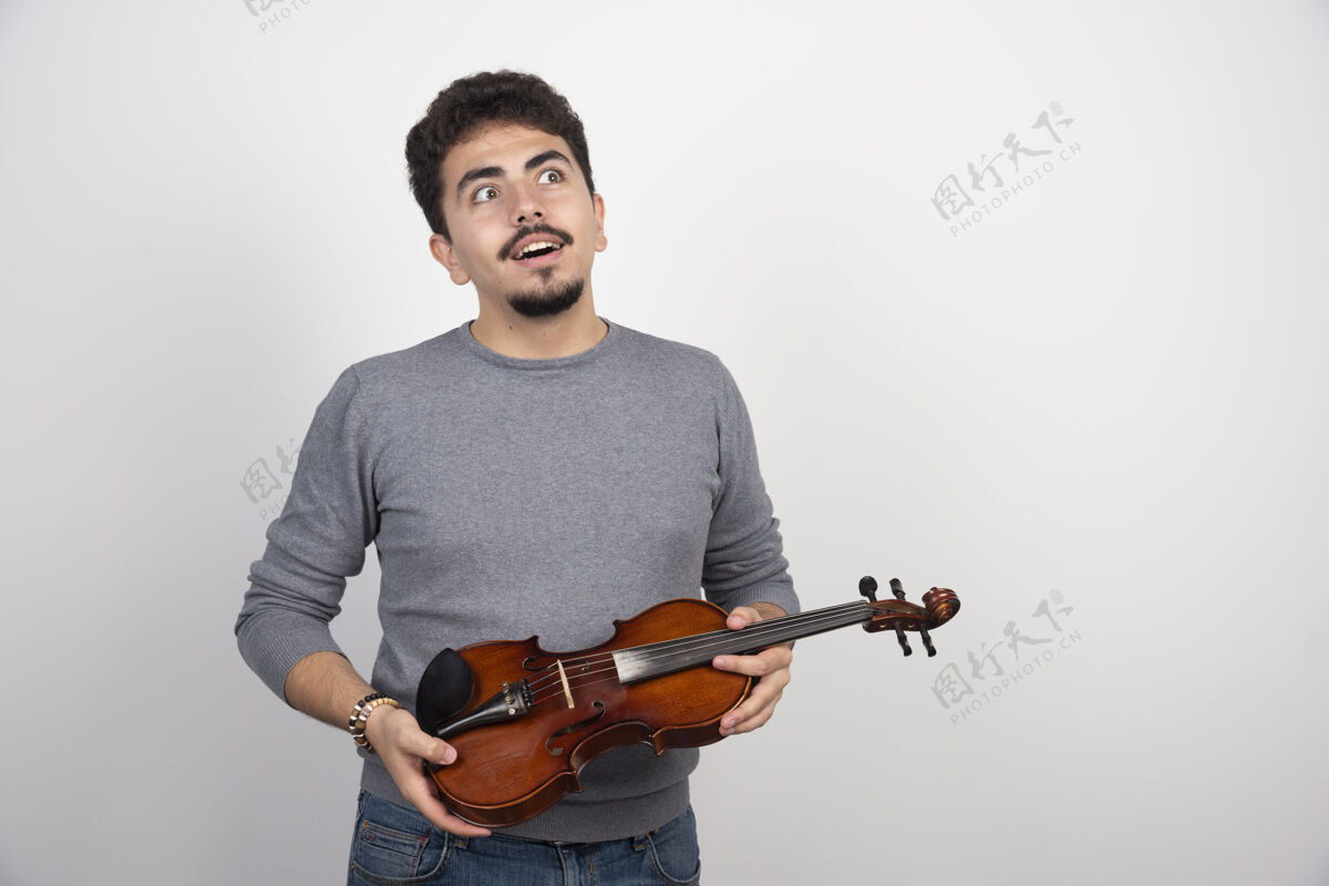 独奏音乐家拿着小提琴 想着下一首要演奏的曲子场景年轻男人