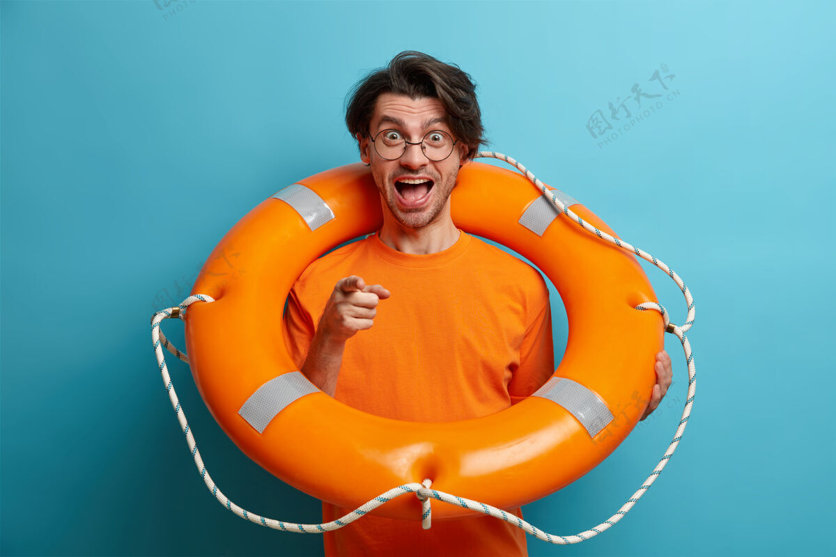 眼镜正面男游客摆出充气游泳圈的姿势 学会直接对着镜头游泳手指救生员安全