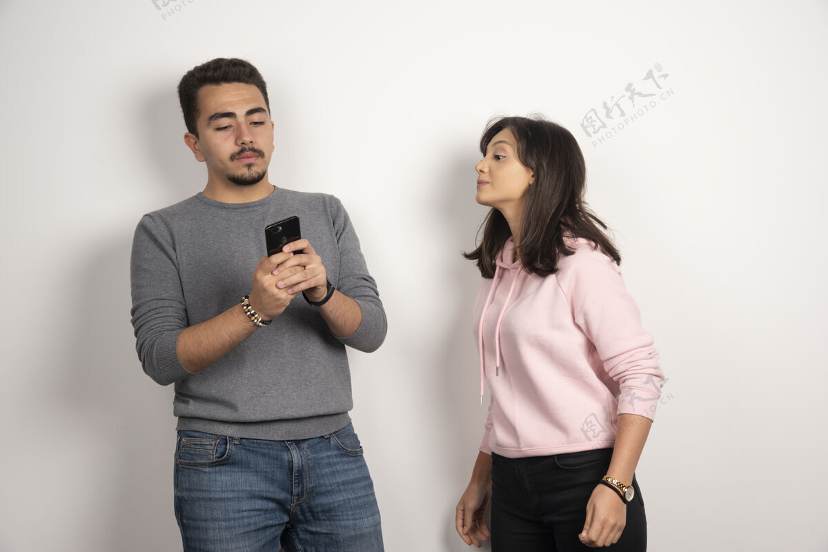 关系一个女人正试着看他的白色手机男人电话人