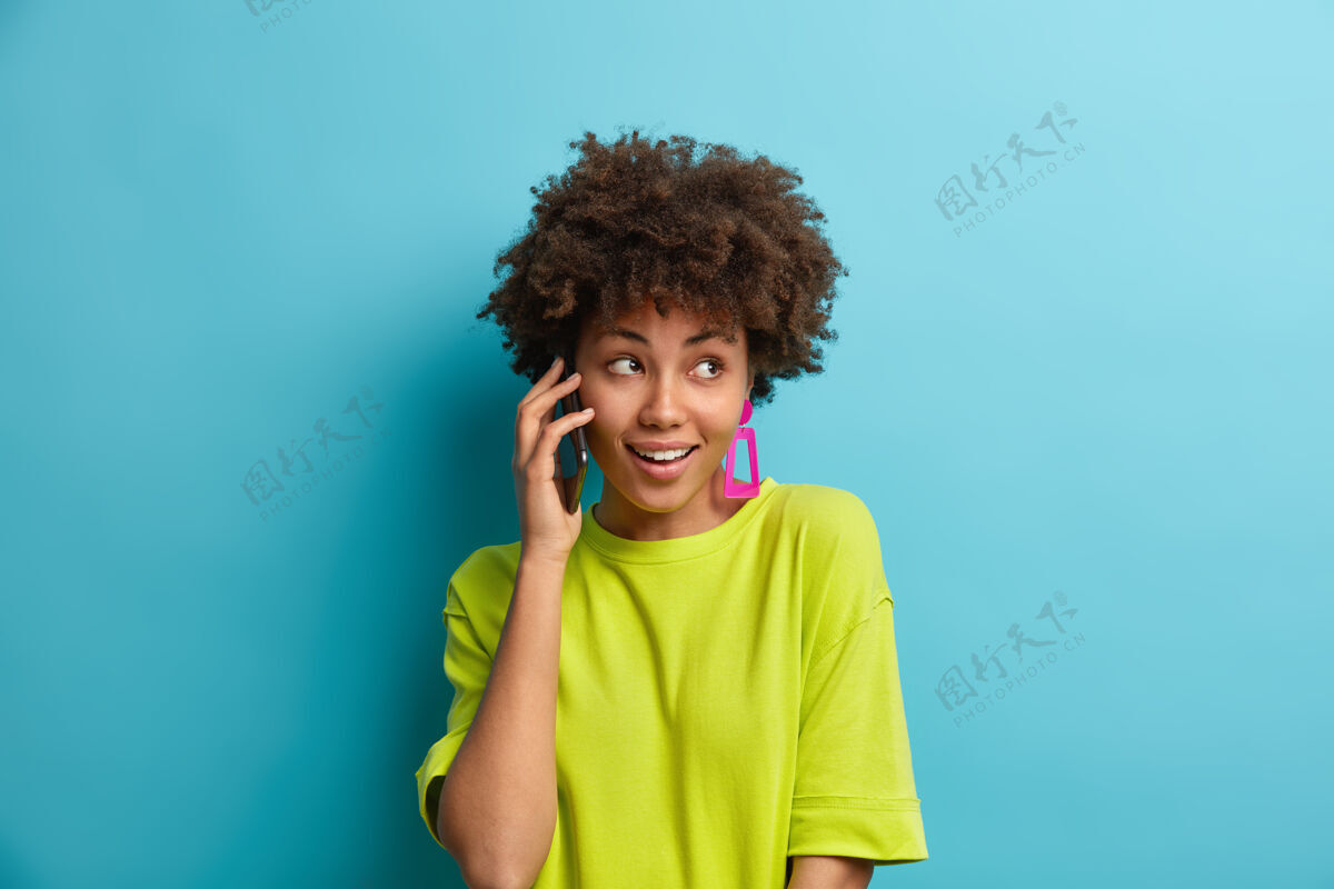 非洲漂亮开朗的卷发女人打电话聊天通过手机交谈有愉快的表情女人黑色人