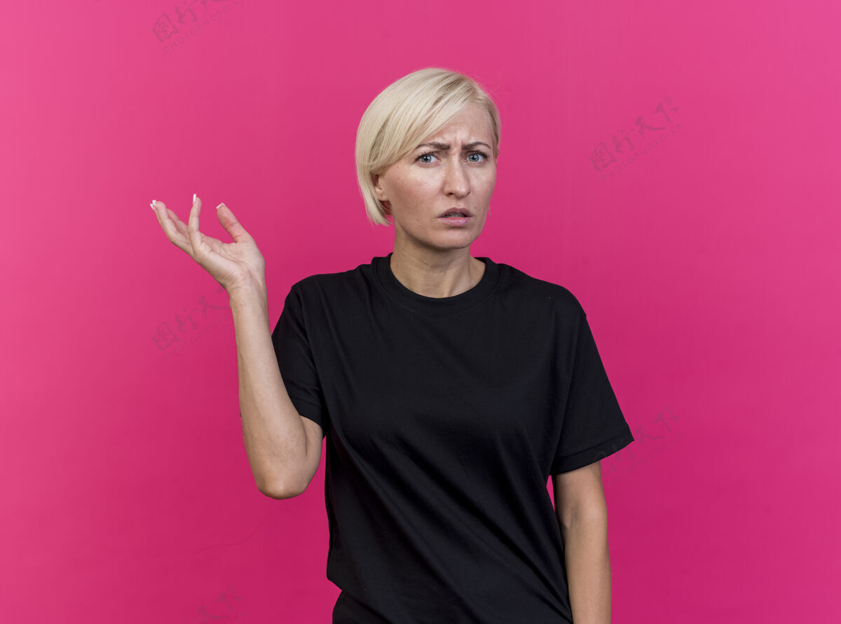 人不知所措的中年金发斯拉夫妇女显示空手看前面孤立的粉红色墙壁与复制空间站脸感情