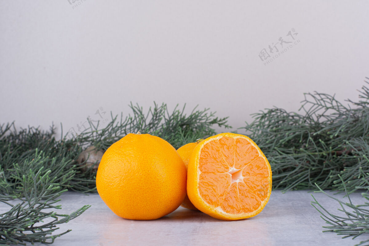 水果橘子捆在白色的松枝旁柑橘橘子果肉