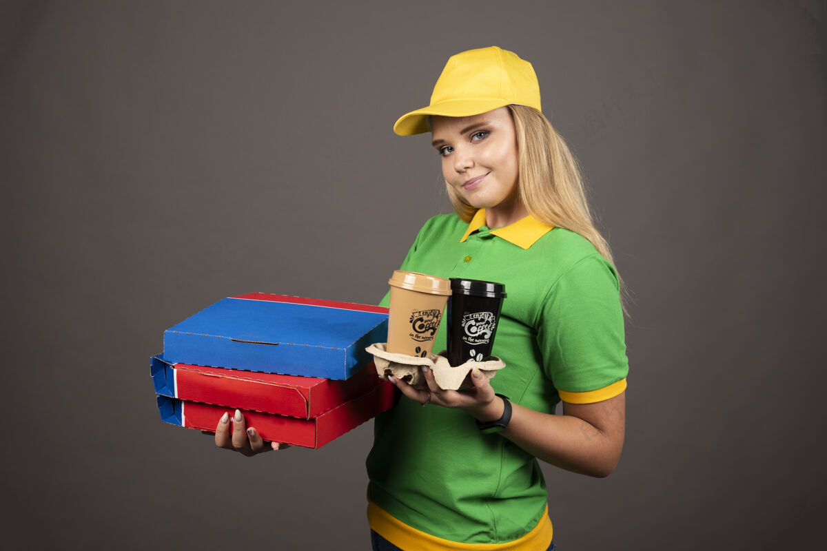 女孩微笑的女送货员拿着咖啡杯和披萨牌高质量的照片脸送货披萨