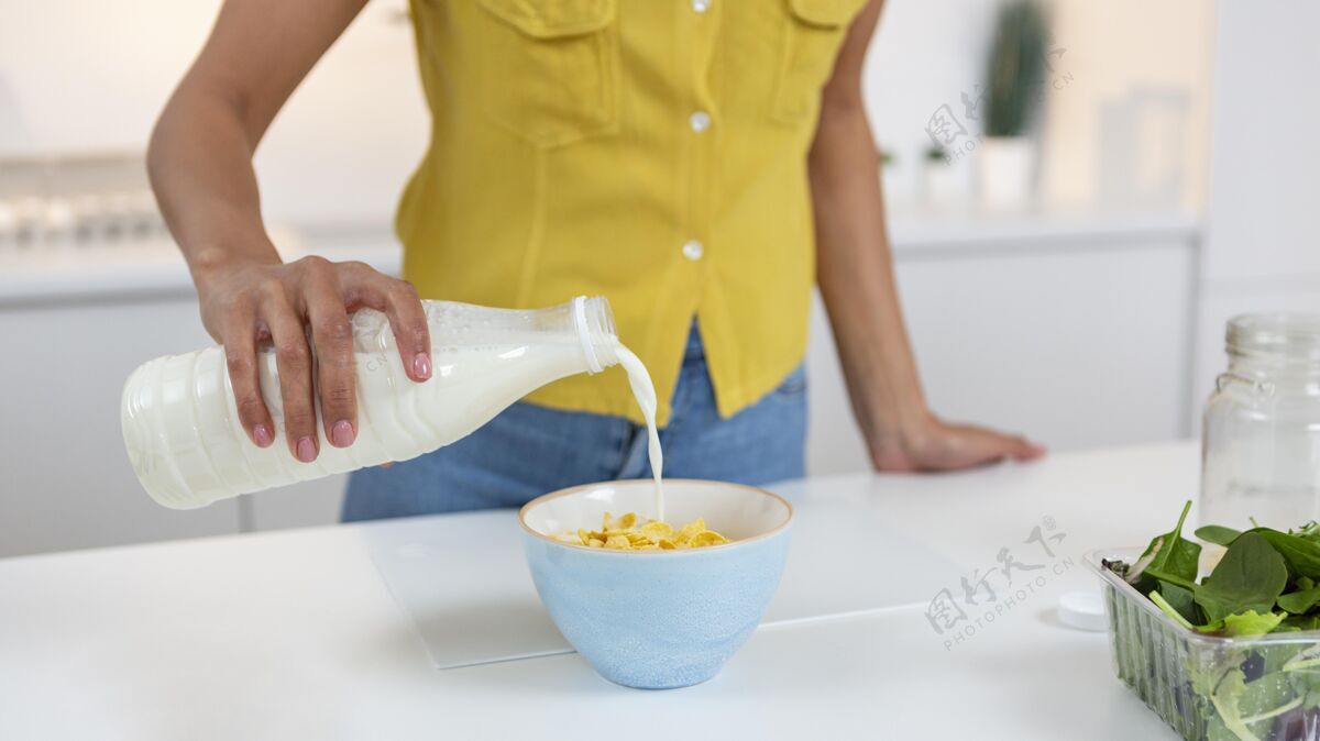 房间准备一碗牛奶麦片的女人生活方式舒适公寓
