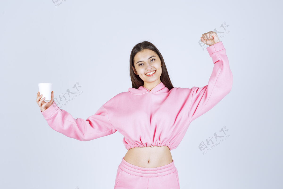 女性穿着粉色睡衣的女孩拿着咖啡杯 伸出拳头人类人能量