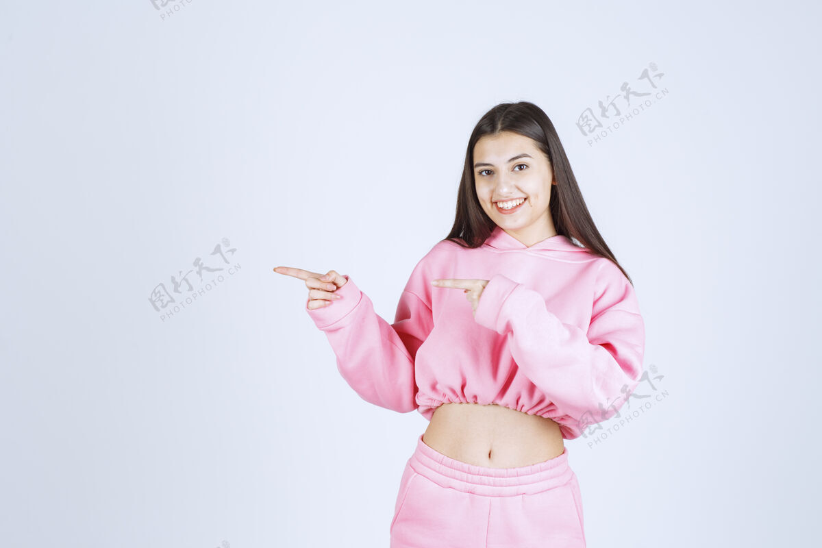 服装穿着粉色睡衣的女孩指着左边的东西休闲人类广告
