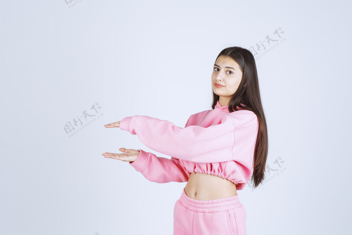 宽度穿着粉色睡衣的女孩 展示了一个物体的大小成人尺寸服装