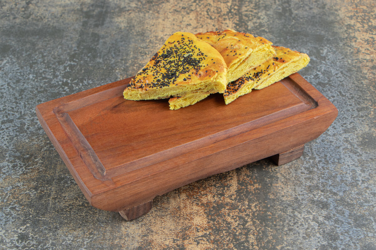 糕点在木板上放罂粟籽的三角形糕点餐罂粟块