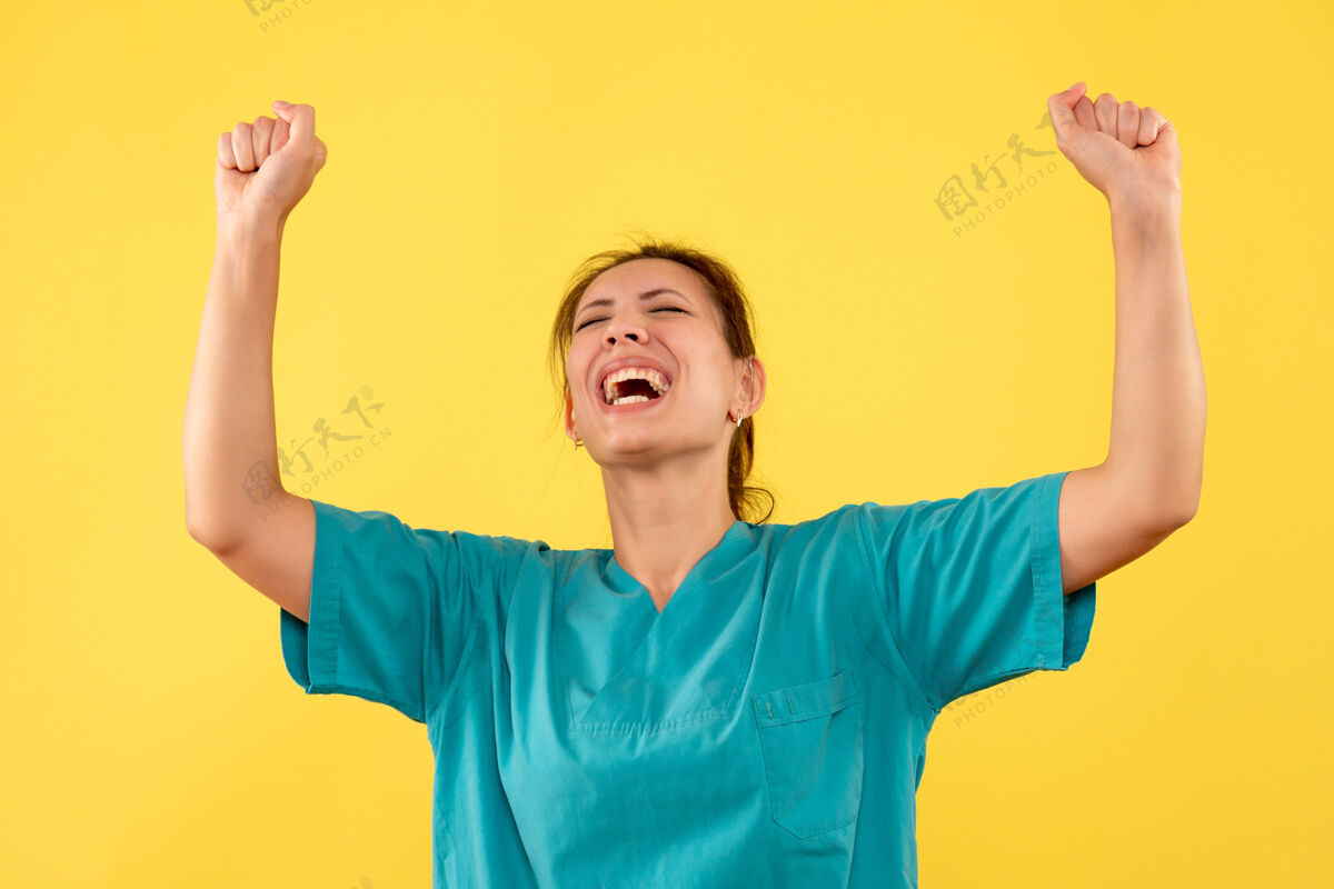 衬衫正面图黄色背景上穿着医用衬衫的女医生欢呼雀跃健康高兴正面
