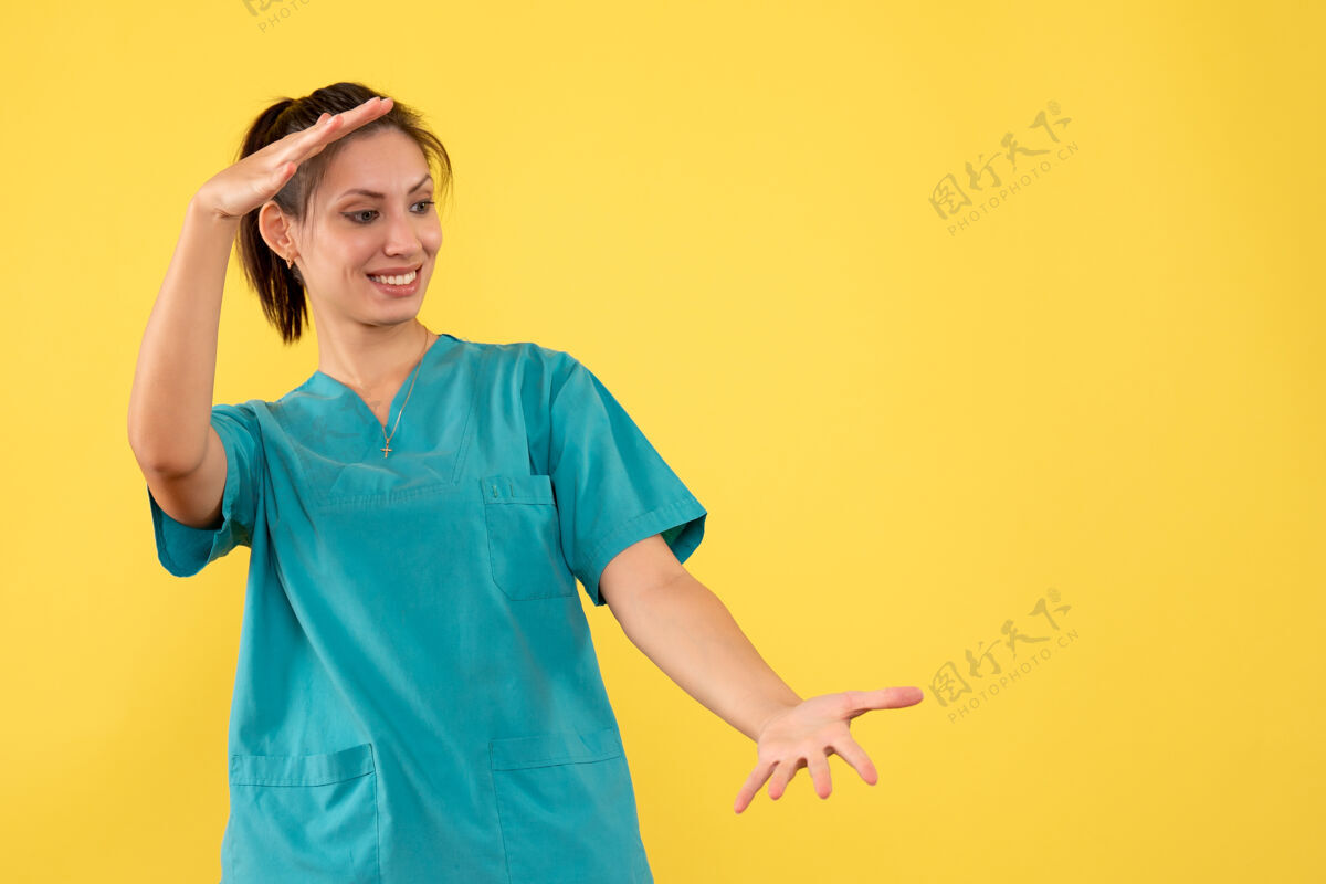 正面前视图黄色背景上穿着医用衬衫的女医生成人医疗黄色
