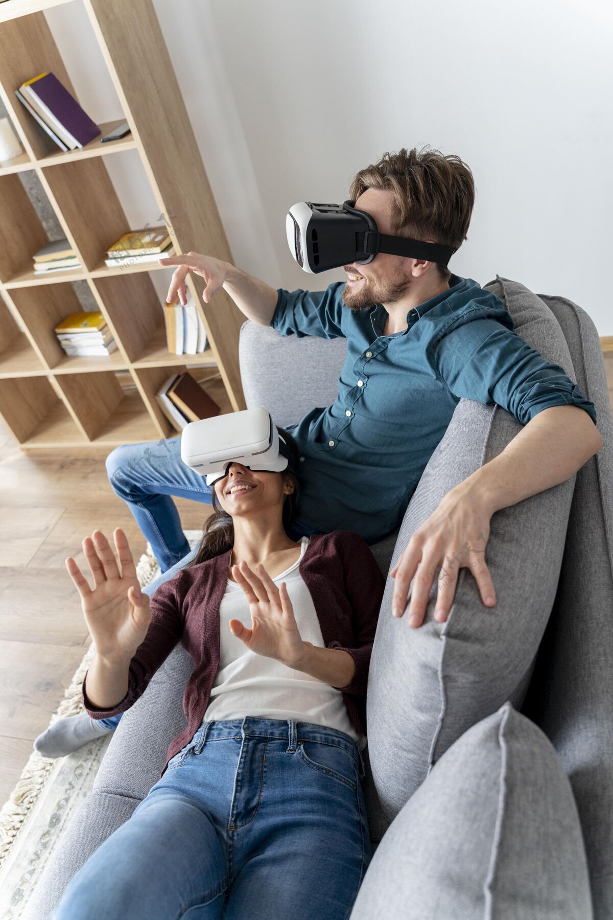 男人男人和女人在家里的沙发上使用虚拟现实耳机垂直房子娱乐