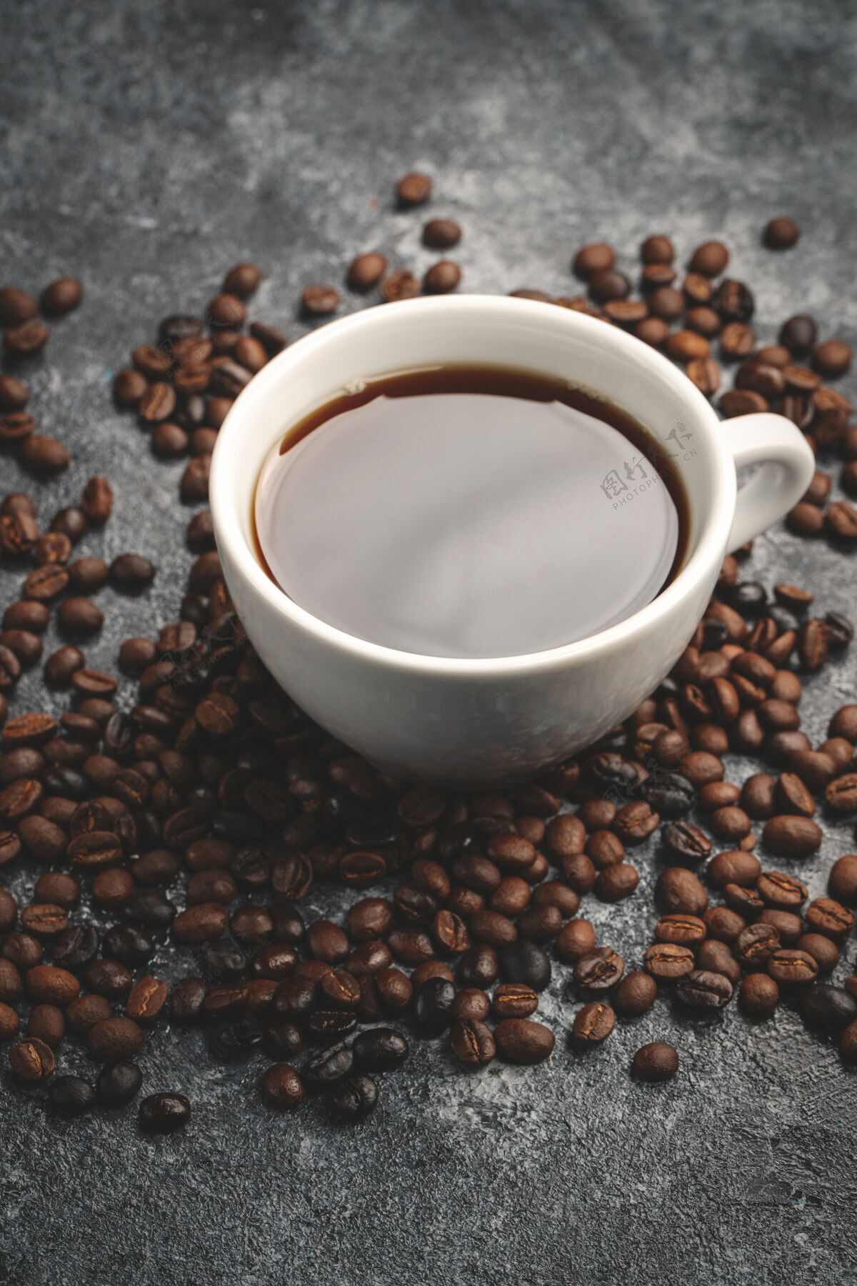 马克杯咖啡籽和咖啡杯的正视图在黑暗的墙上烤棕色浓缩咖啡