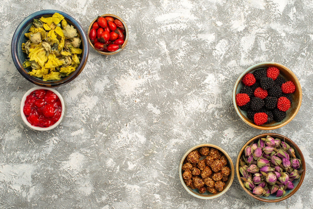 晚餐顶视图浆果与坚果和干花在白色背景confiture糖果茶甜茶午餐盘子