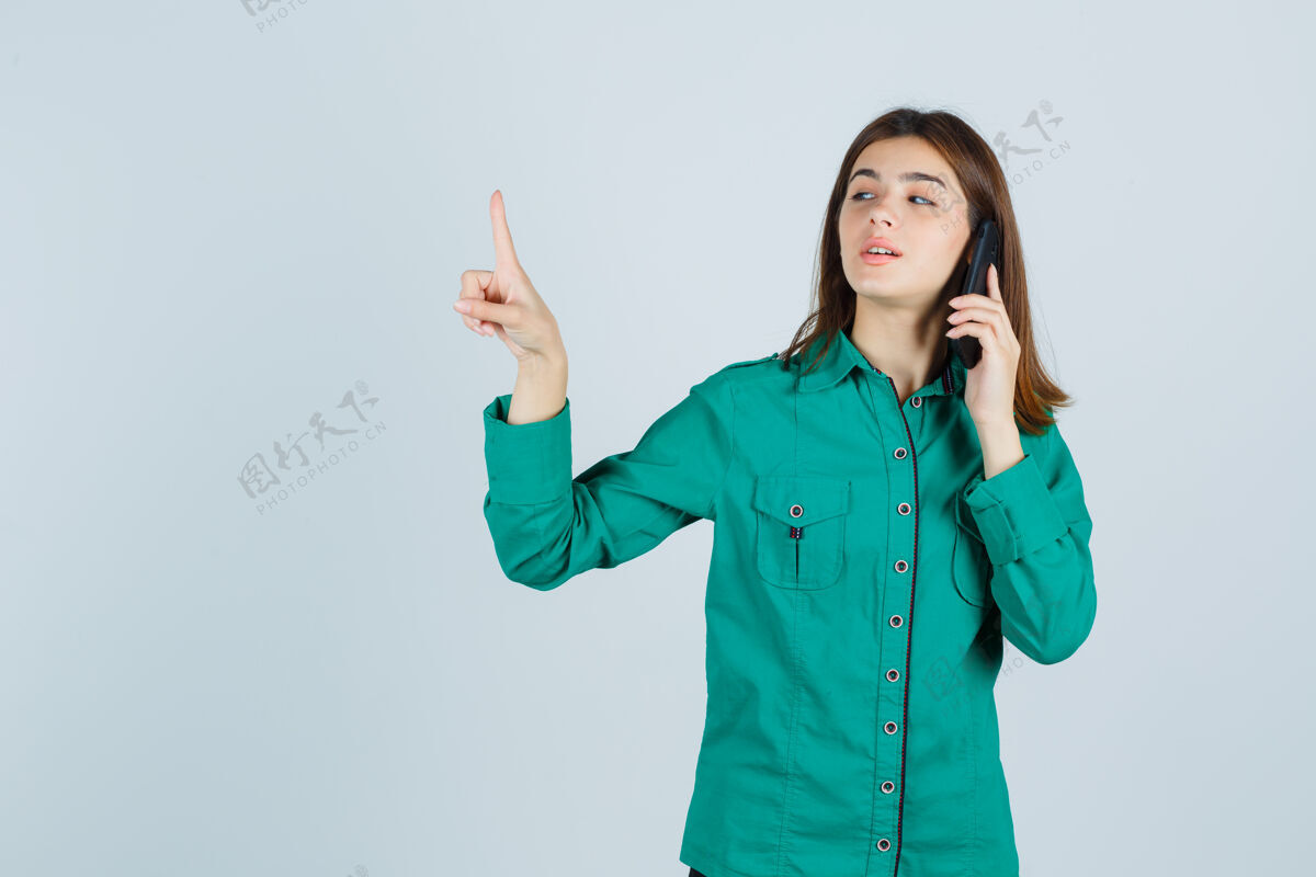 成人穿着绿衬衫的年轻女士在讲手机 保持一分钟的姿势 看起来很自信 前视年轻专业女性