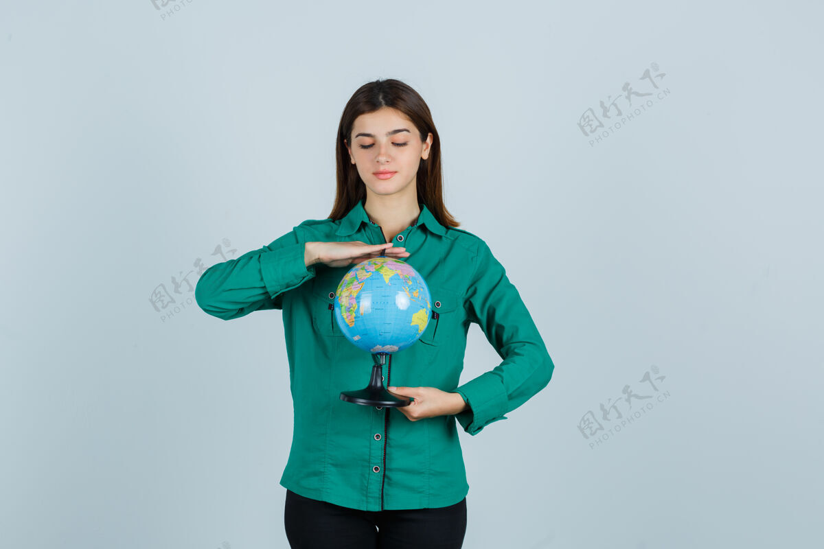 女性穿着绿色衬衫的年轻女性看着地球仪 仔细地看着前方的景色护理人休闲