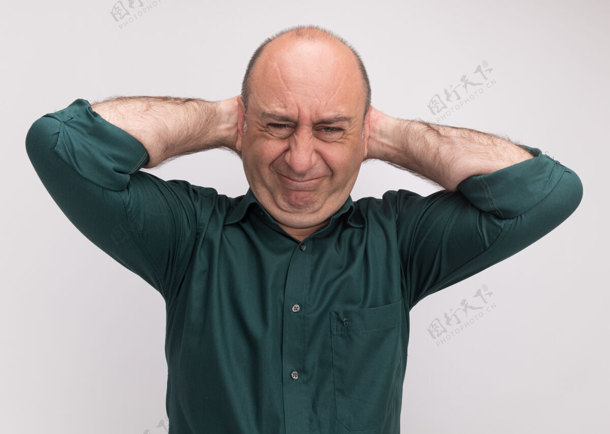 穿遗憾的中年男子穿着绿色t恤 把手放在脑后隔离在白墙上中年男人T恤