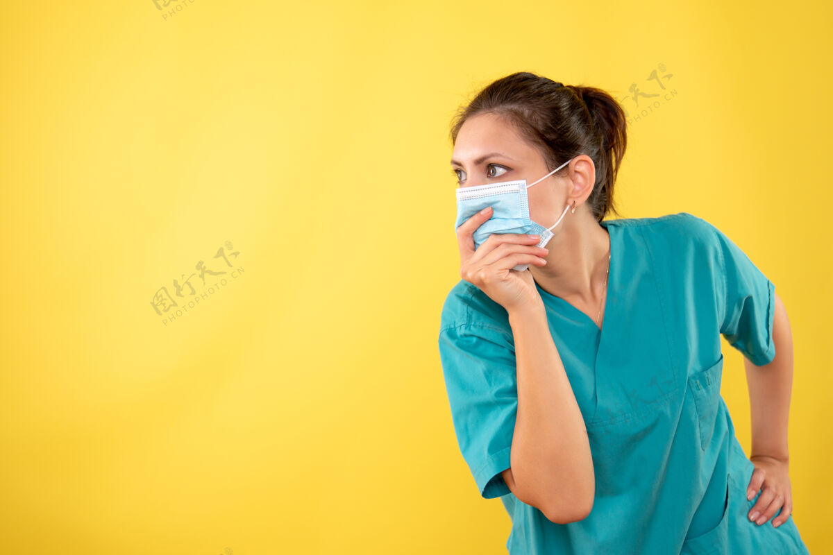 医疗黄色背景上戴着防护面具的女医生的前视图黄色健康呼叫