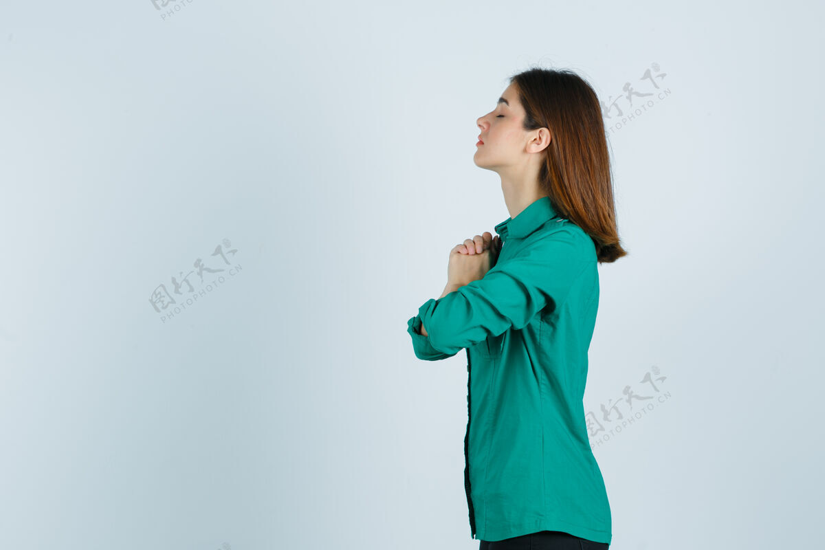 祈祷穿着绿色衬衫的年轻漂亮女士双手合十祈祷 看上去充满希望手势太阳沉默