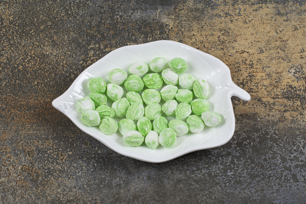 糖果绿色薄荷醇糖放在叶子形状的盘子里芳香薄荷邦邦