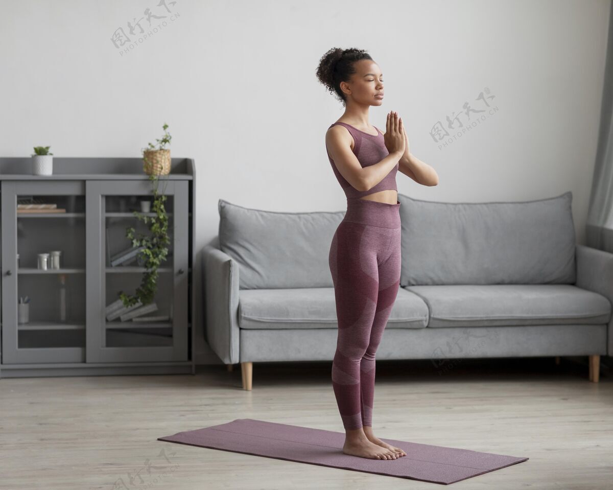 健康健身女士在家里用瑜伽垫做瑜伽心灵瑜伽姿势身体