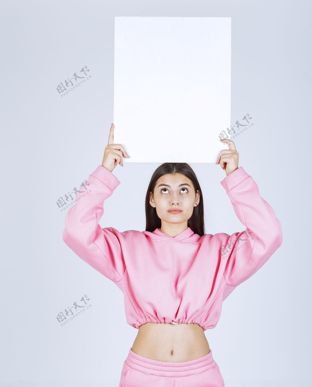 工人穿着粉色睡衣的女孩头上举着一块空白的方形展示板 让每个人都能看到晋升女人聪明