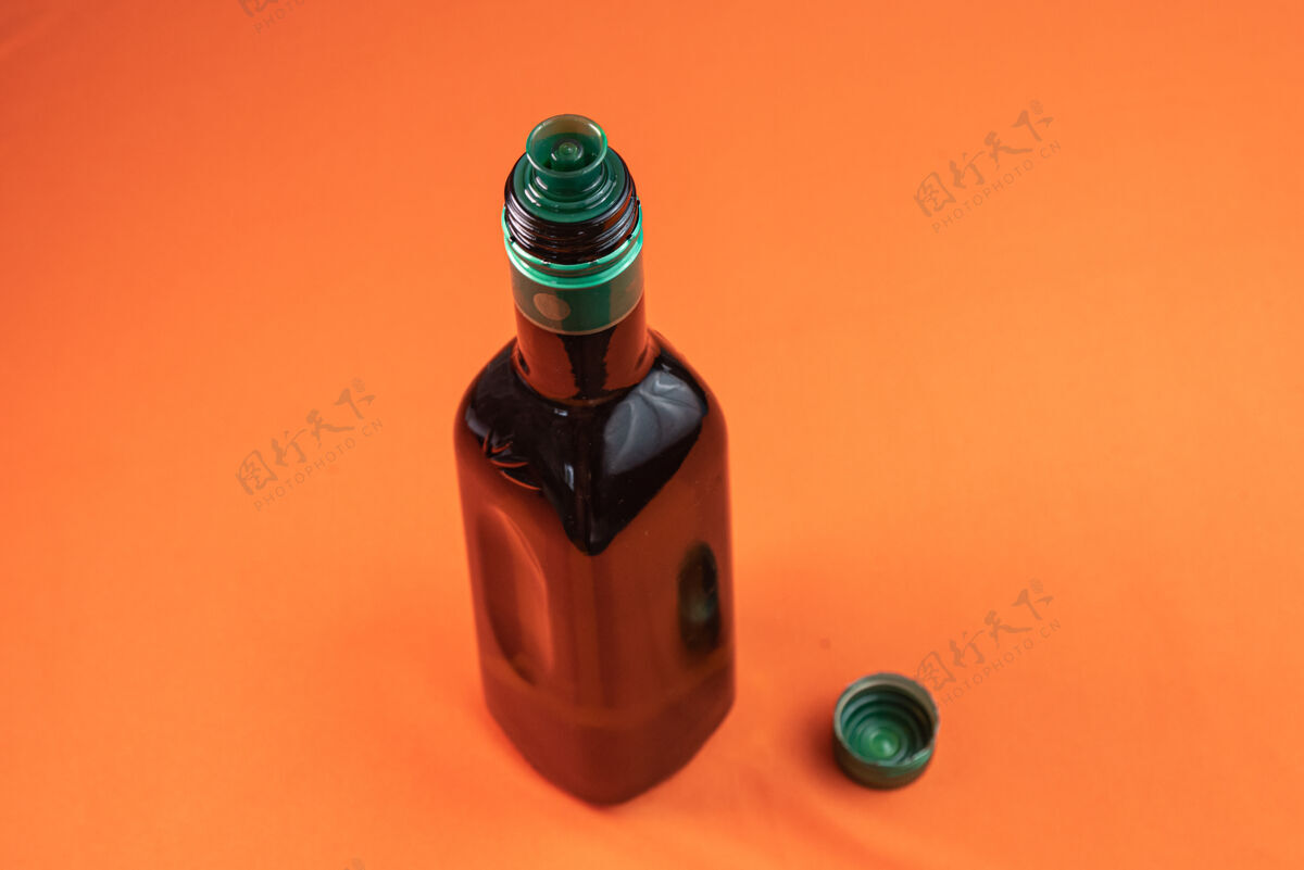 自然橙色表面上的橄榄油容器液体调味品橄榄