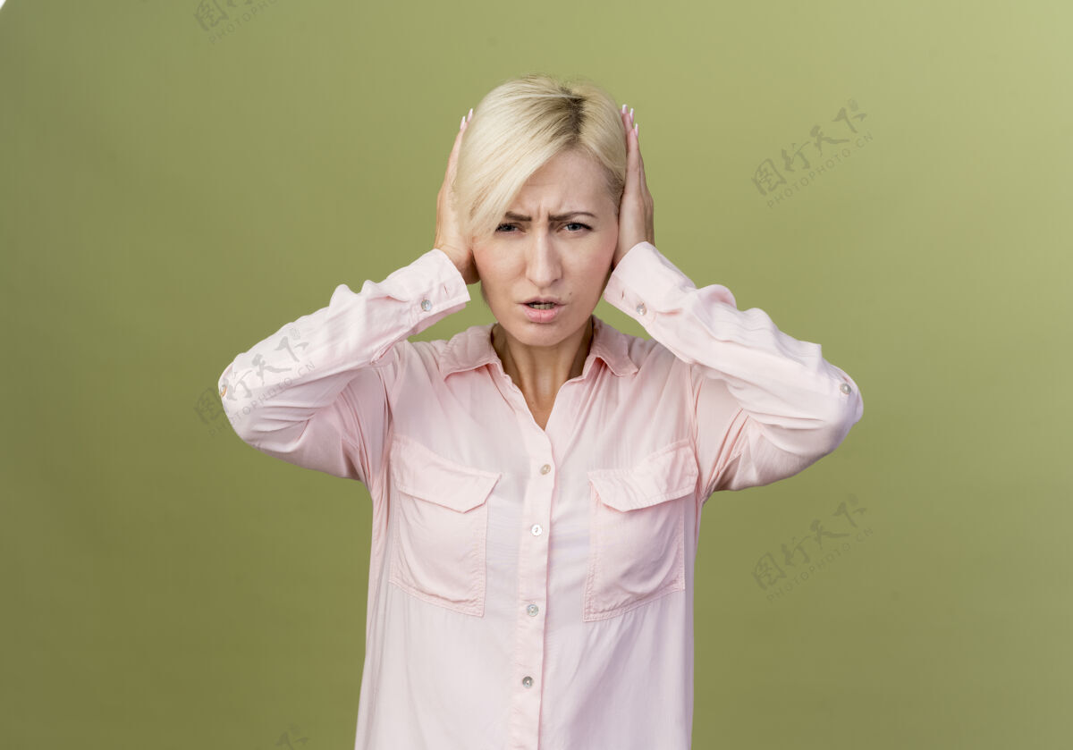 绿色年轻的金发斯拉夫女人用手捂住耳朵橄榄掩护噪音