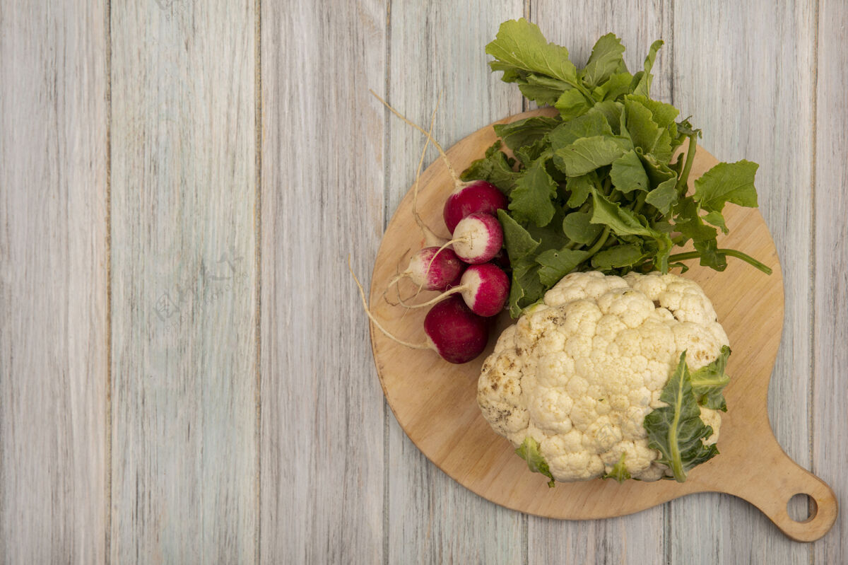 花椰菜健康菜花的顶视图在一个木制的厨房板上与萝卜在一个灰色的木制表面与复制空间有机饮食健康