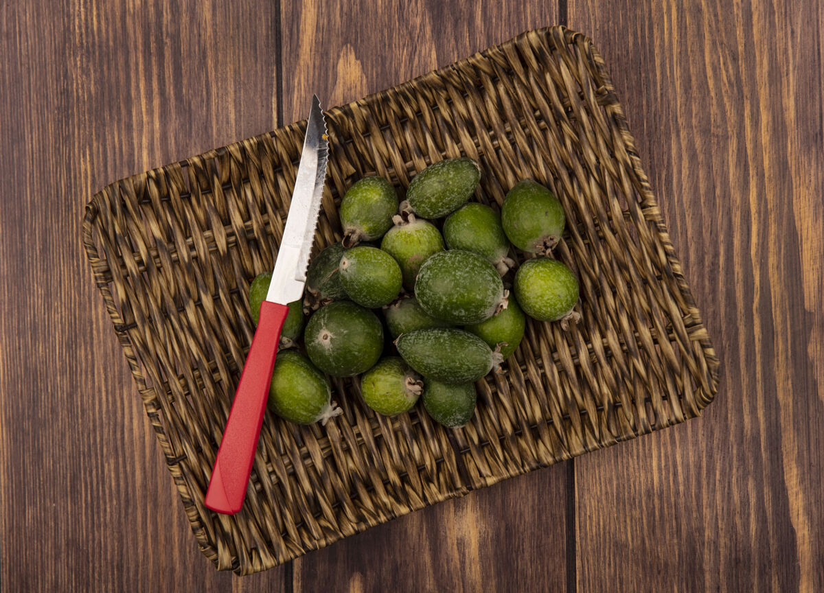 新鲜在柳条托盘上的新鲜绿色feijoas顶视图 刀放在木制表面上柳条美味营养