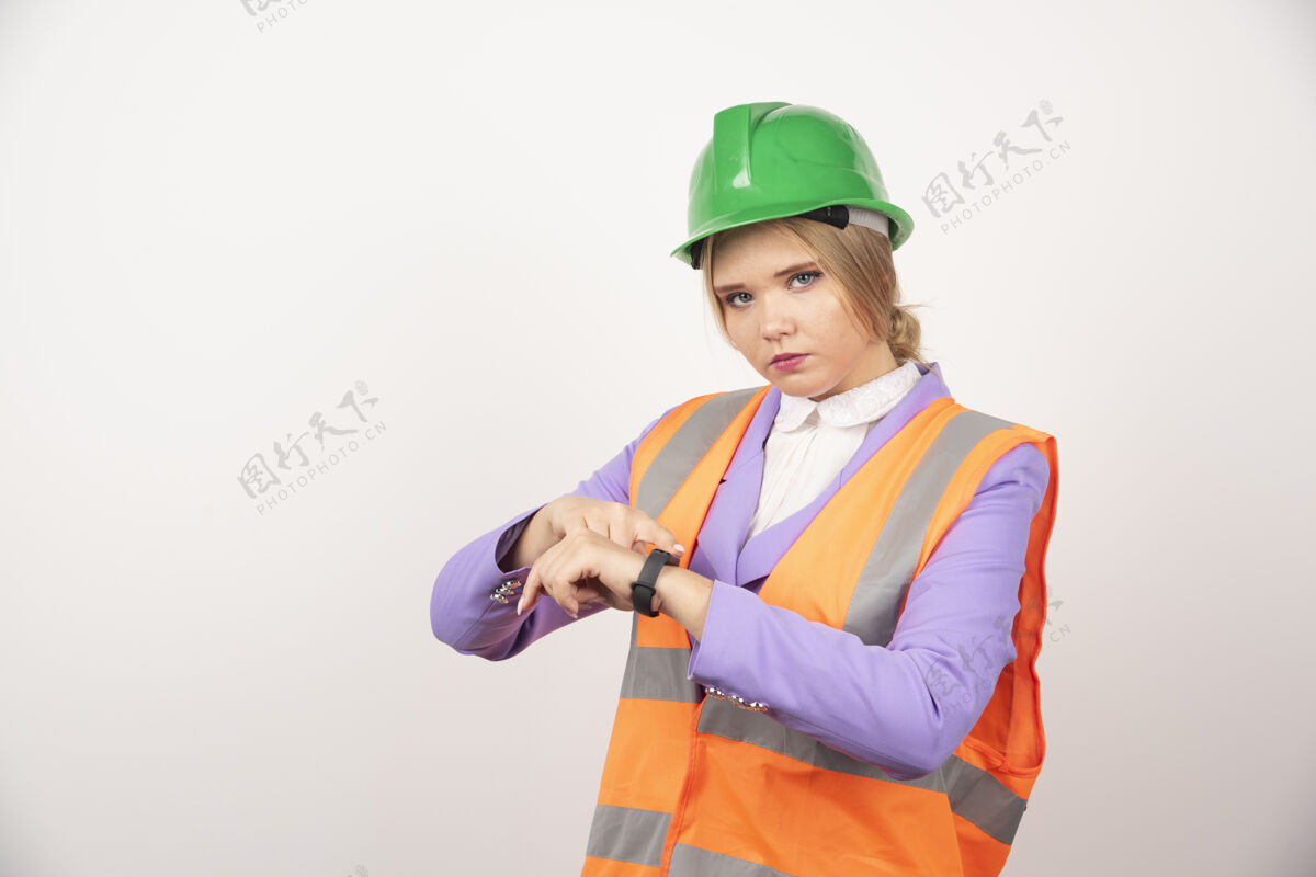 金发女员工指着白墙上的时间安全帽头盔工人