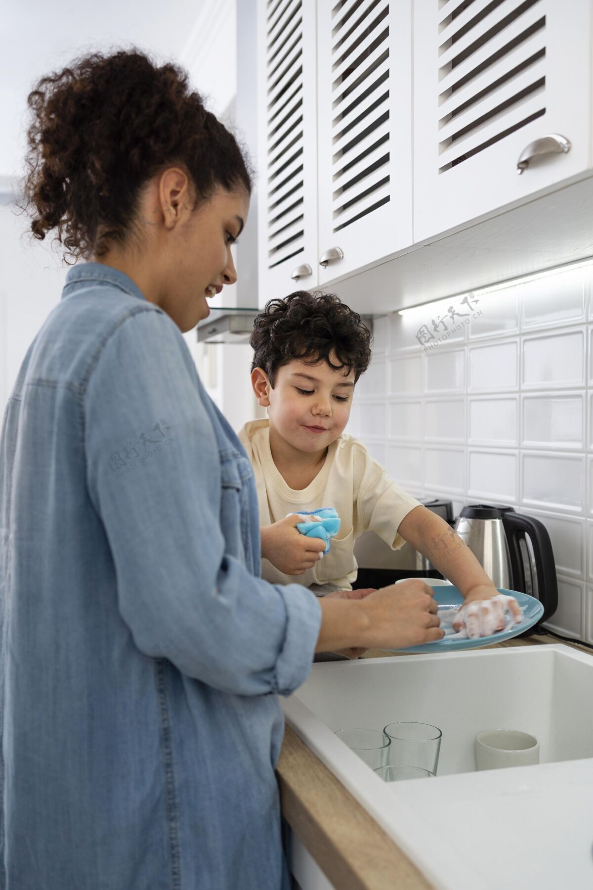 黑人年轻妈妈和儿子一起洗碗家庭女人幸福的家庭