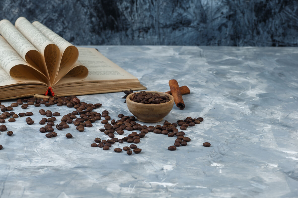 大理石关闭咖啡豆在木制碗与书 肉桂浅色和深蓝色大理石背景水平休息味道想法