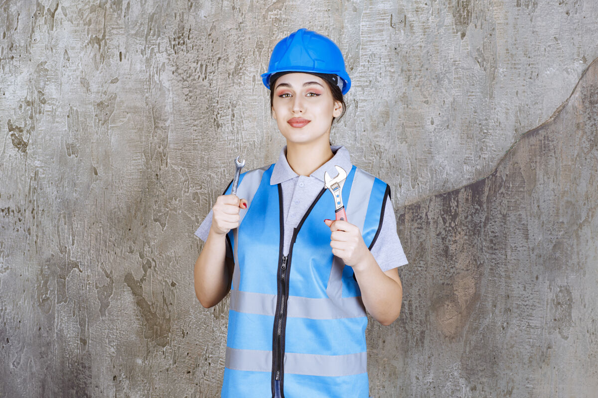 员工身穿蓝色制服 头戴钢盔 手持金属扳手的女工程师聪明员工模型