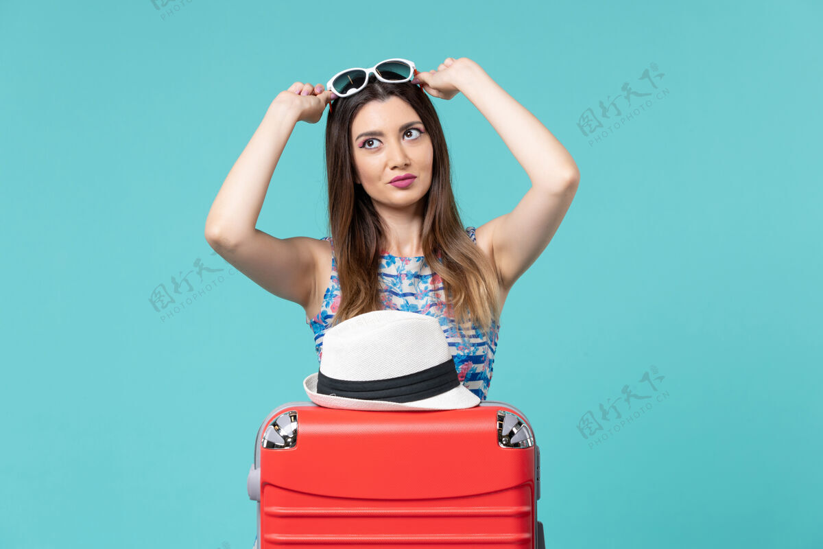 美丽的女性前景色美丽的女性戴着太阳镜在蓝色空间准备度假准备海穿