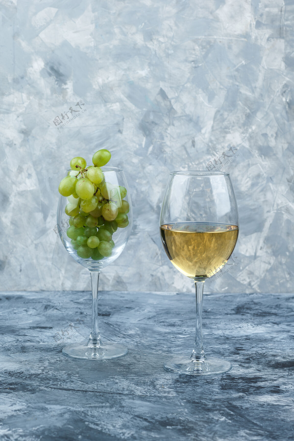 自然在深蓝色和浅蓝色大理石背景上 用一杯威士忌和一杯白葡萄把杯子关起来垂直成熟新鲜果汁