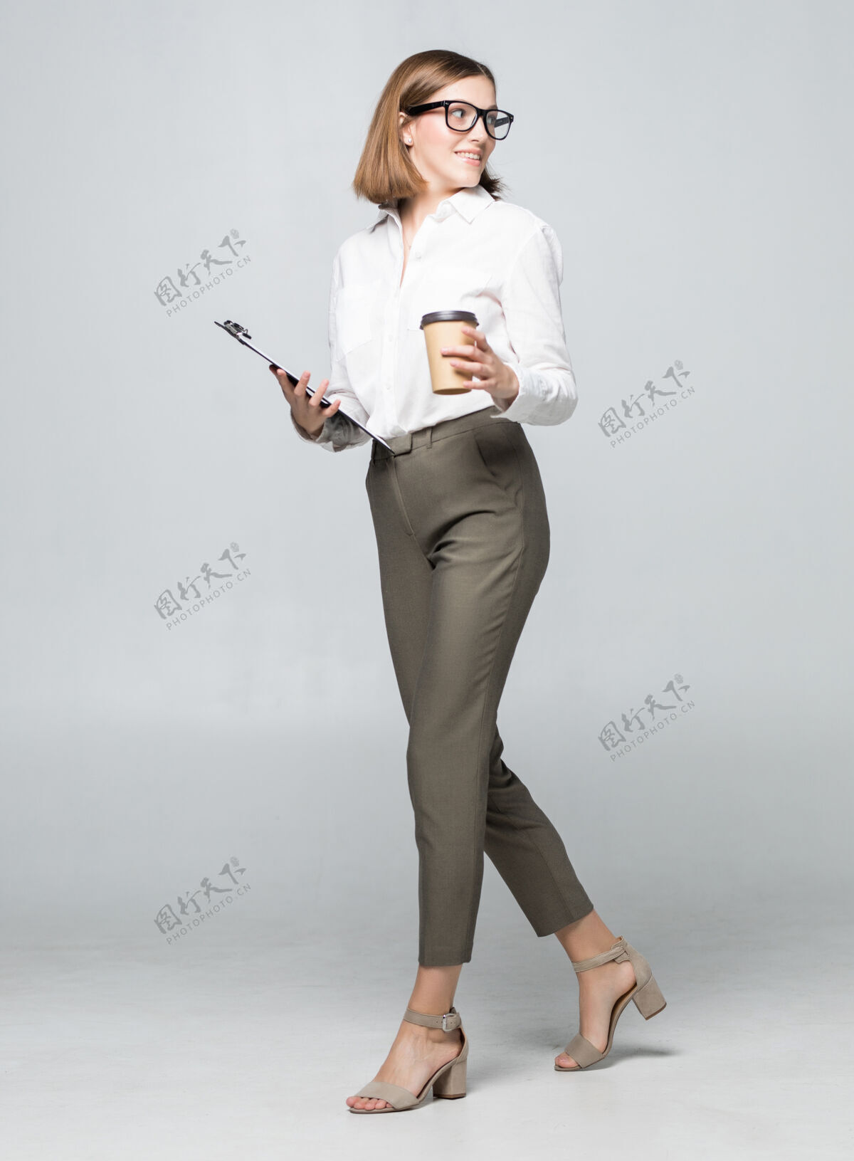 领带年轻漂亮的女人喝着咖啡 隔着白色的墙壁女性女士工人