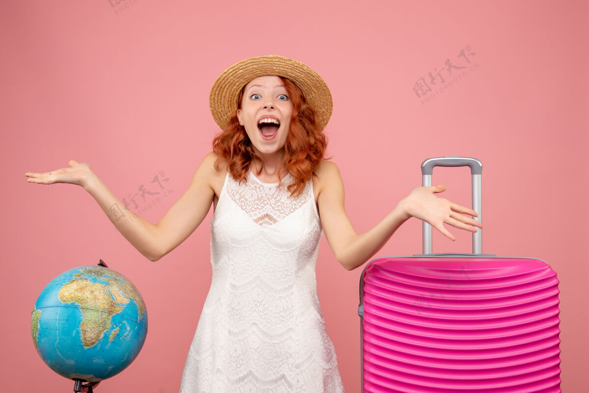 肖像年轻女性游客的正面图 浅粉色的墙上挂着粉色的包人包衣服