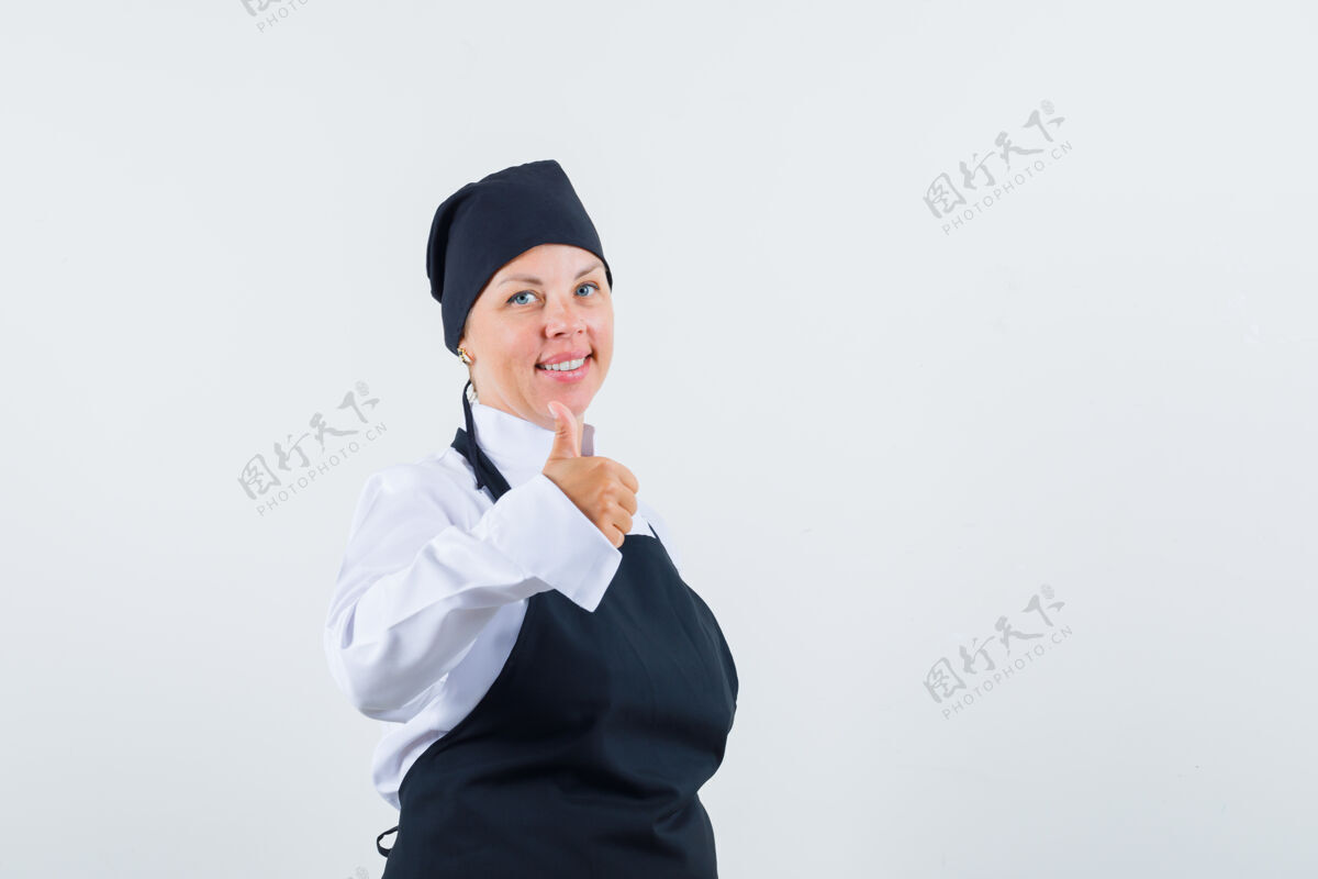 优雅女厨师穿着制服 围裙 竖起大拇指 看上去很高兴前视图模特卷发休闲