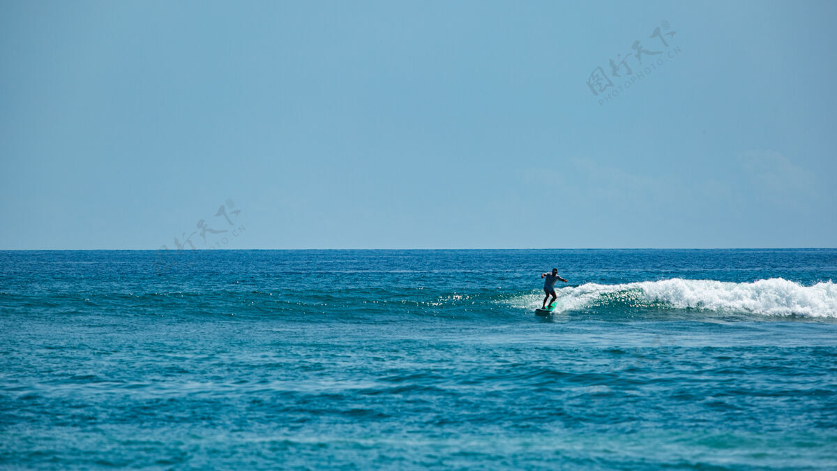 运动员在蓝色波浪上冲浪运动活动印度尼西亚