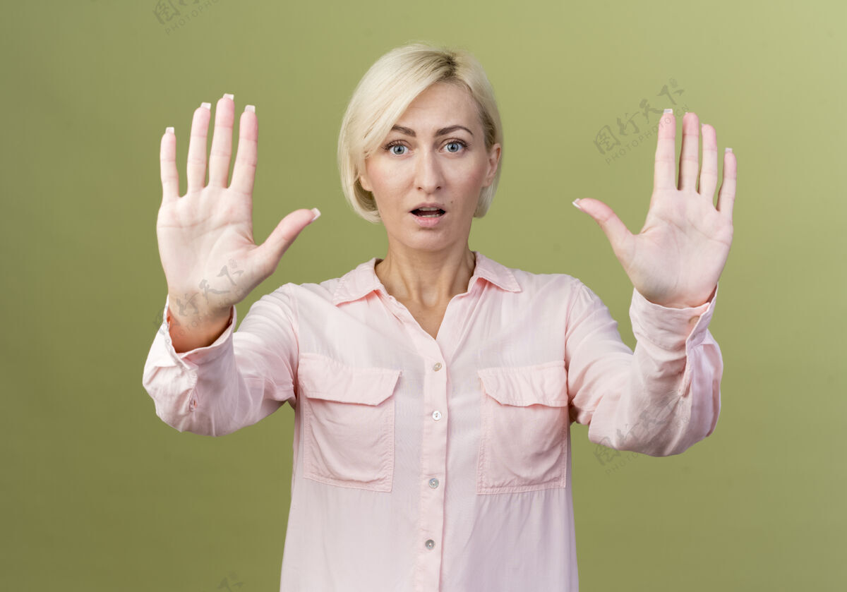 年轻惊讶的年轻金发斯拉夫妇女显示停止手势孤立的橄榄绿墙上女人手势奥利弗
