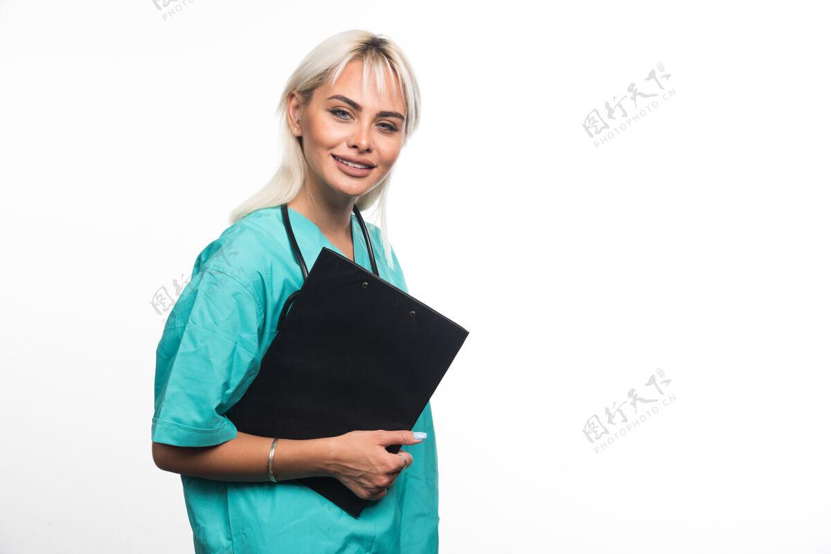 制服面带微笑的女医生拿着白纸上的剪贴板人类听诊器拿着