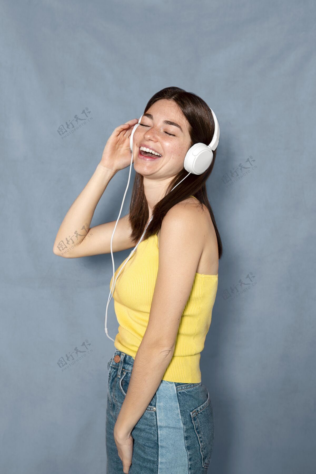 笑脸笑脸女人用耳机玩得开心模特耳机年轻