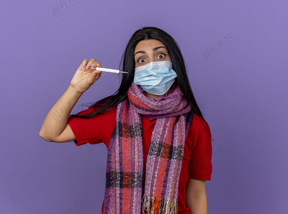 印象印象深刻的年轻白种人生病的女孩戴着面具和围巾拿着温度计水平隔离在紫色墙上的复制空间年轻疾病水平
