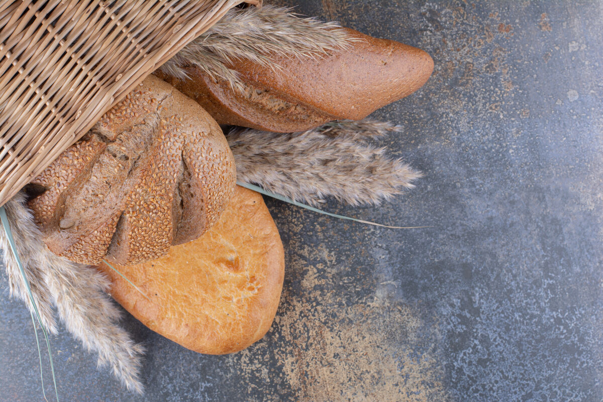 面包屑一篮子面包和羽毛草在大理石表面面包皮草面粉