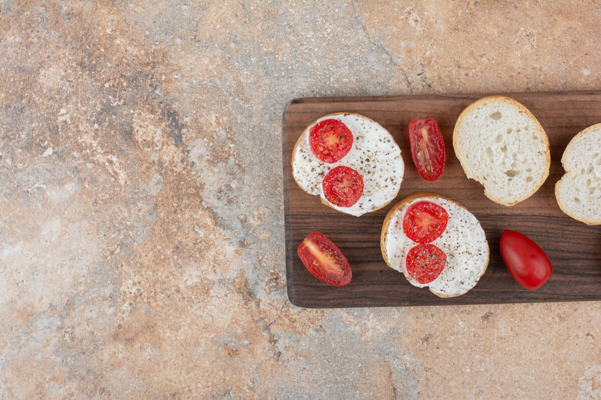 切片面包片加奶油和番茄放在木板上吐司番茄奶油