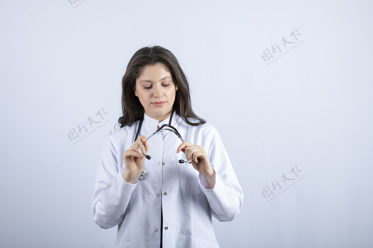 医疗保健年轻的医生在看白墙上的听诊器女孩护士专家