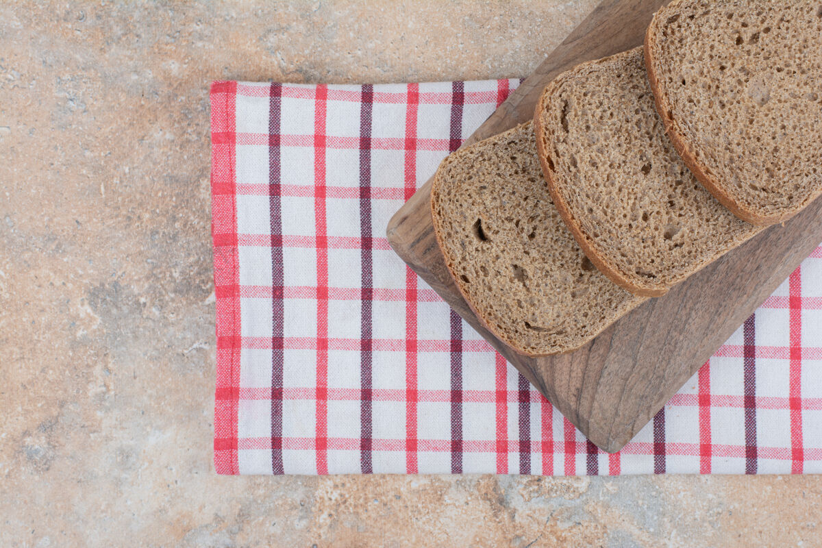 桌布用桌布把黑面包片放在木板上谷类食品面包房黑麦