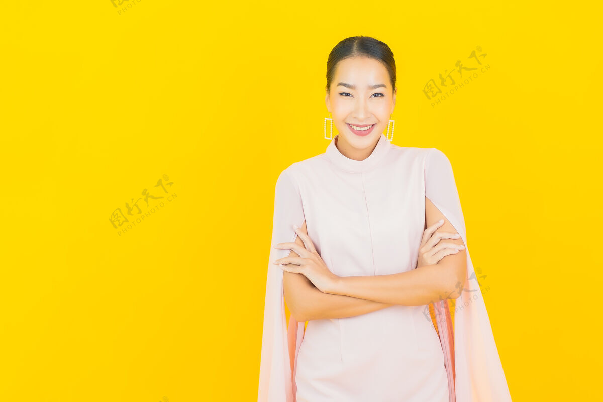 亚洲人画像美丽的亚洲年轻女子微笑着在黄色的墙上有许多动作乐趣学生人